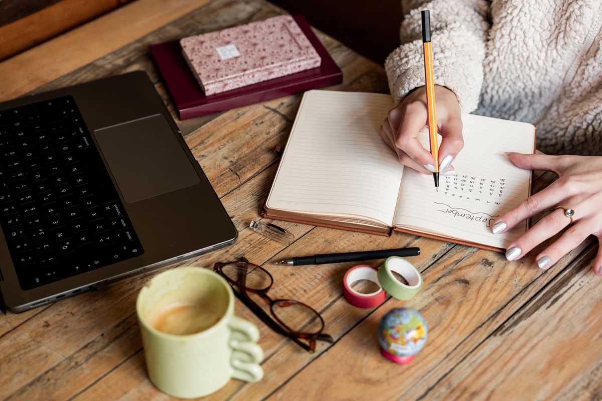Marketer writing a strategy plan in a notebook