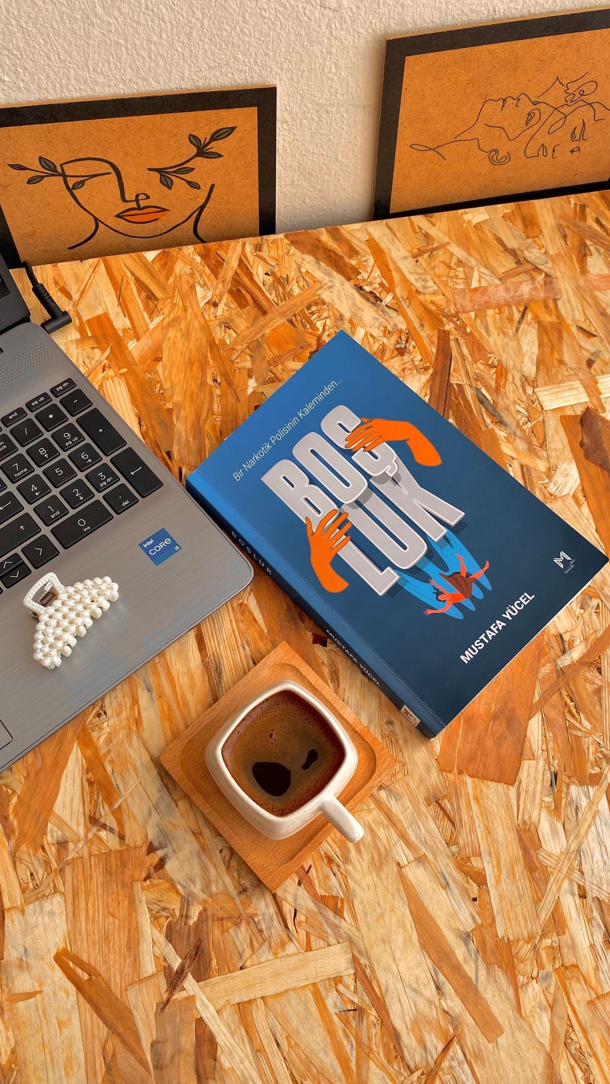 Cozy workspace with a laptop, book, and coffee for writing